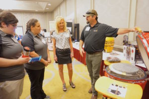 People show product features of a BBQ pit