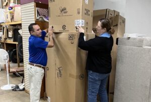 Frank Gonzales and Jen Troke putting their backs into offloading an Ashley Furniture Industries order.
