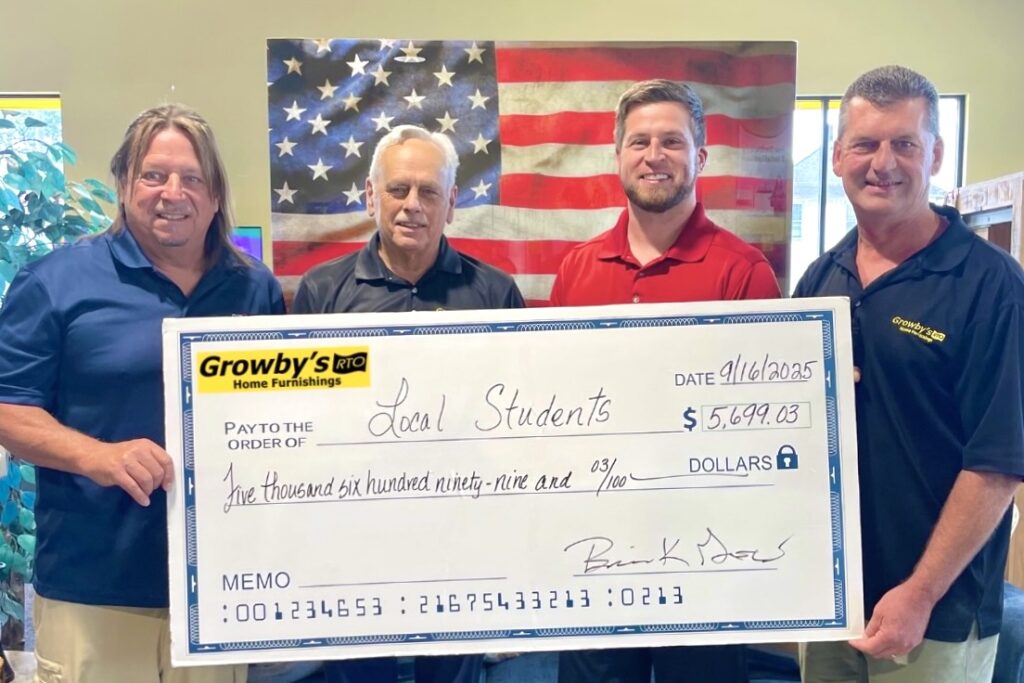 Growby’s Owner Brian Grow (far L), along with team members (L to R) Rick Aikman, Eric Grow, and Kevin Tanksley, proudly present a check from the company’s first Back-to-School Fundraiser for education. 