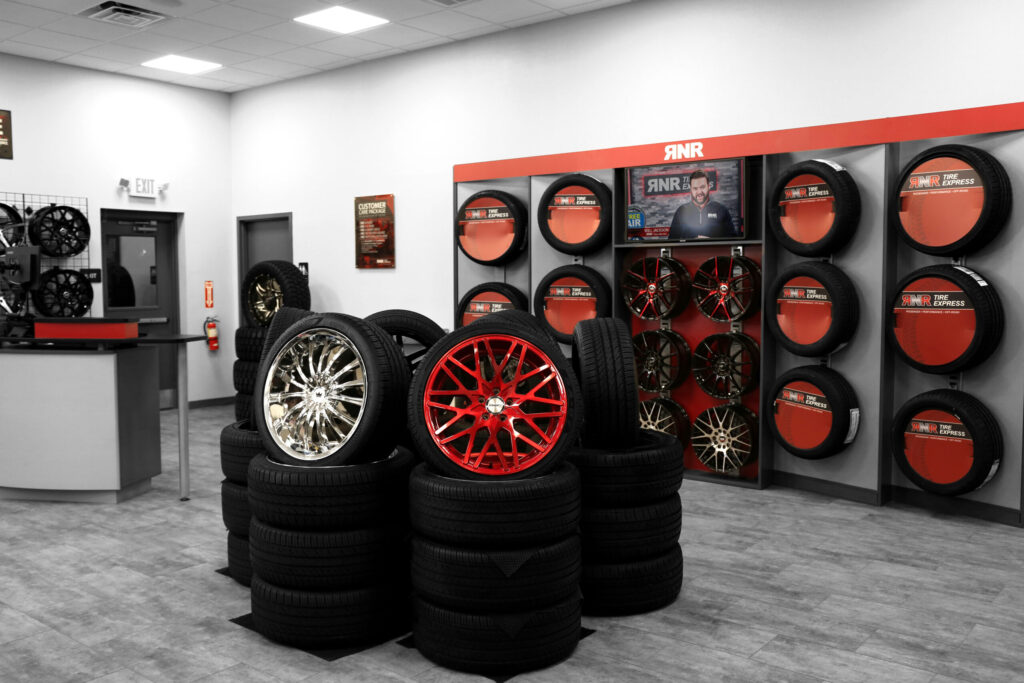 Tires are displayed in a red, black, and silver showroom. 
 
