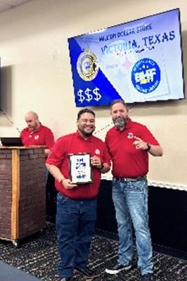 Two BHF team members stand together smiling and holding an award.