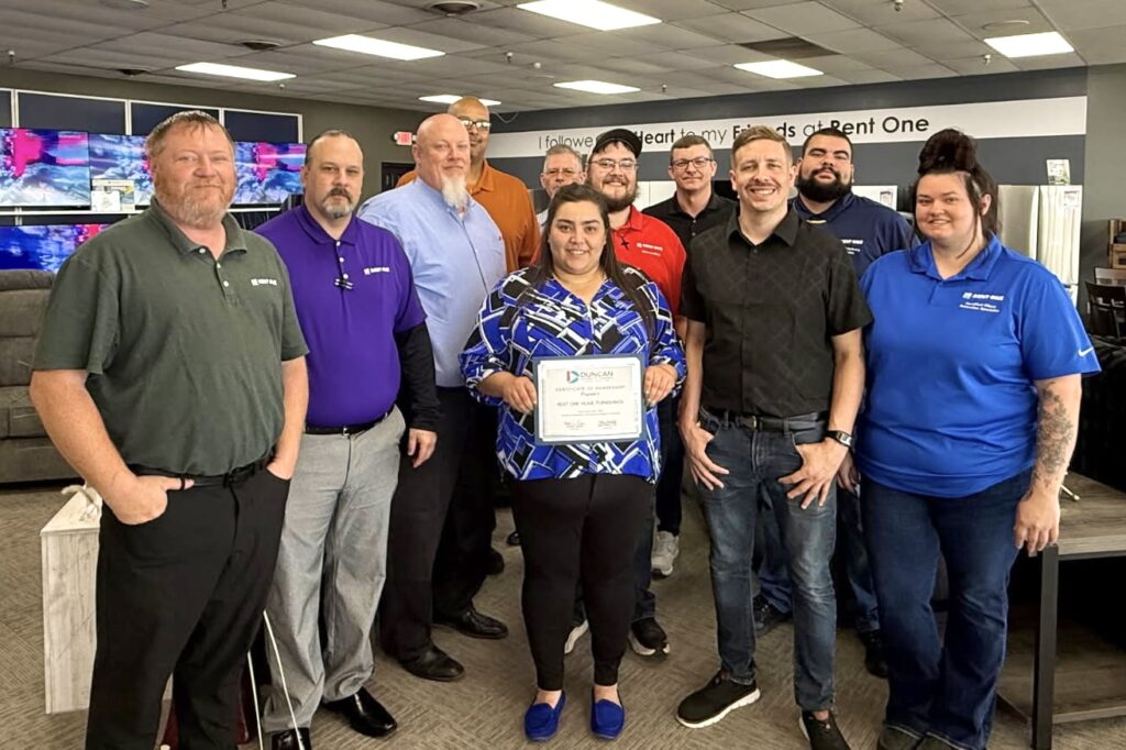 Store Manager Pamela Horn (holding certificate) celebrates the grand opening of her Rent One location in Duncan, Oklahoma, supported by her team, several other area Rent One Store Managers, and her Regional Sales Manager. 