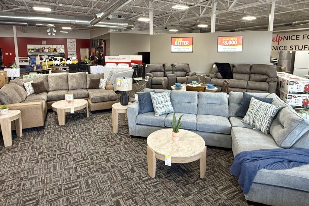 A full showroom displays several living room sets, a few dining room sets, and a washer and dryer.
