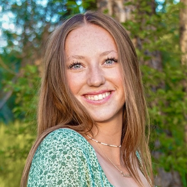 A young blonde woman smiles.